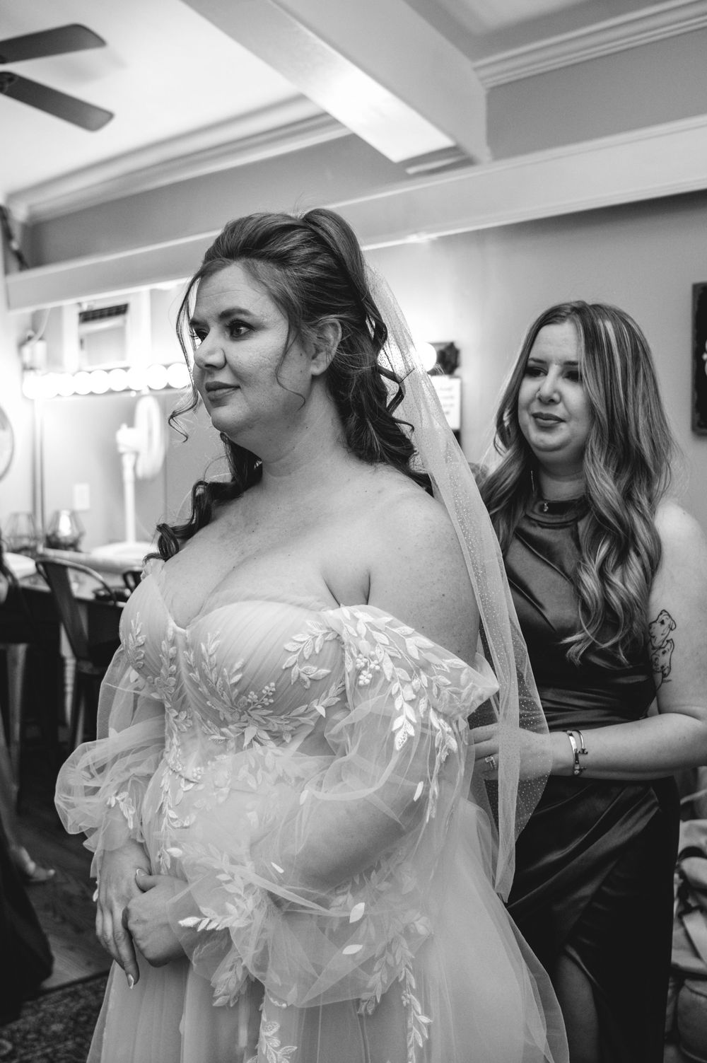 A series of black and white photos showing preparations and candid moments in a bridal suite before a wedding ceremony.