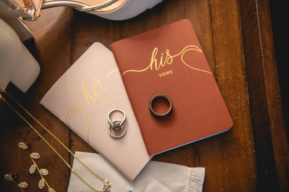 Wedding stationery and invitation cards in brown and blush pink tones arranged on a wooden surface.