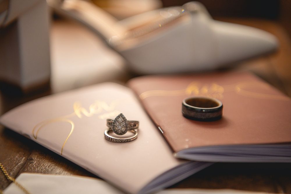 Close-up of wedding rings and rings on leather bound books with shallow depth of field.