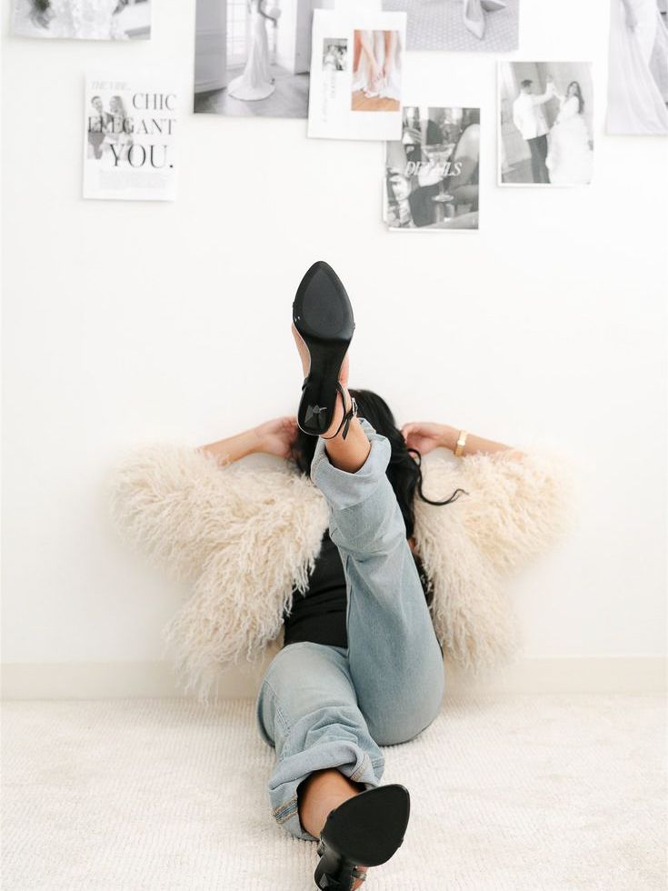 A person in gray loungewear and black socks lies on a white floor in various relaxed poses against a wall with photos.