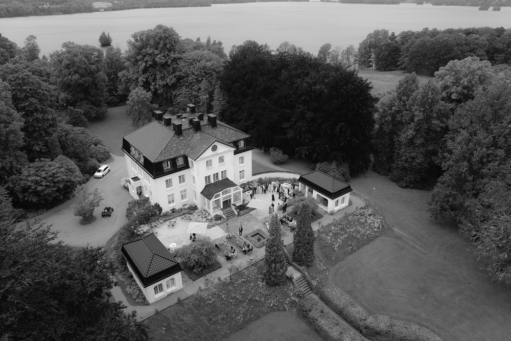 Aerial black and white photos show a sequence of residential properties and buildings surrounded by trees and landscaping.