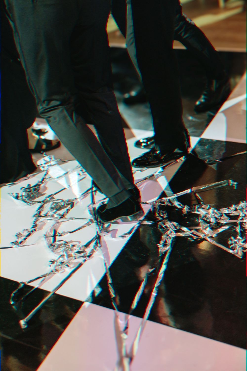 Confetti scattered on a dark reflective dance floor at a celebration event.