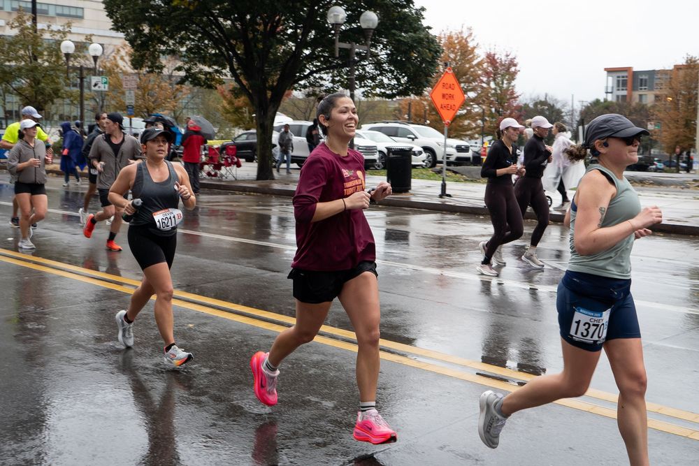 Marathon runners splash through puddles on a rainy race day as they compete in an urban road race event.