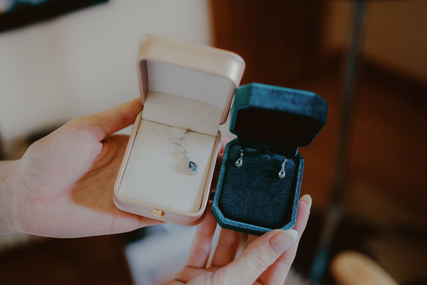 Close-up view of a delicate engagement ring box being opened to reveal a sparkly diamond ring.