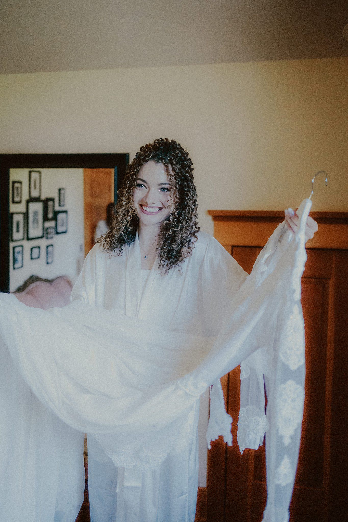 Person in white flowing dress twirling and dancing in an indoor setting with natural light.