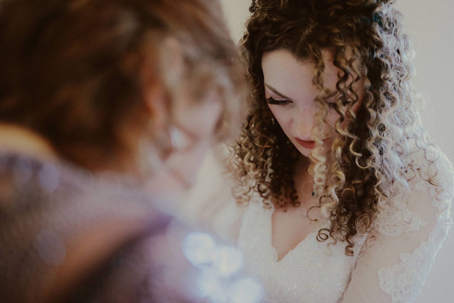 Intimate moment during wedding preparations with soft natural lighting.