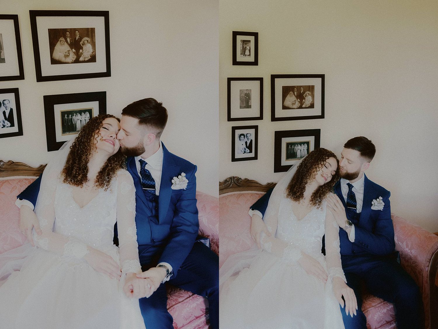 A couple in wedding attire share an intimate moment in front of a wall decorated with framed photographs.
