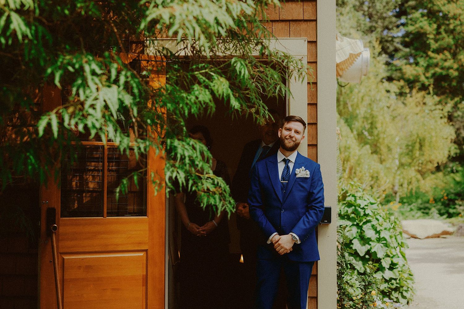 A rustic wedding venue entrance decorated with greenery and natural wood elements.