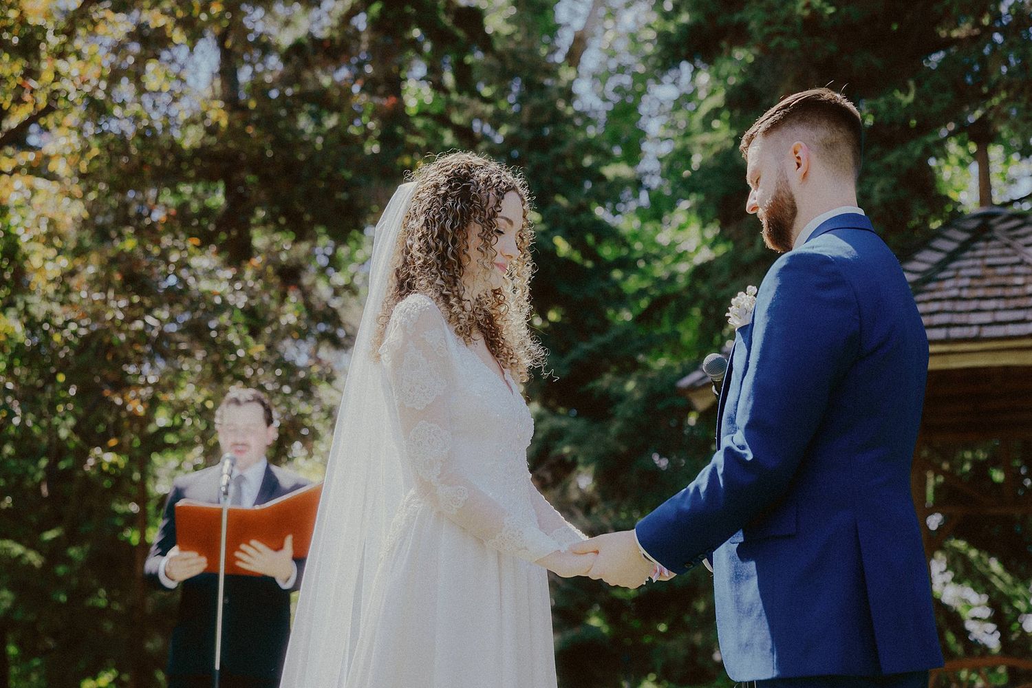 Couple exchanges vows during an intimate outdoor garden wedding ceremony.