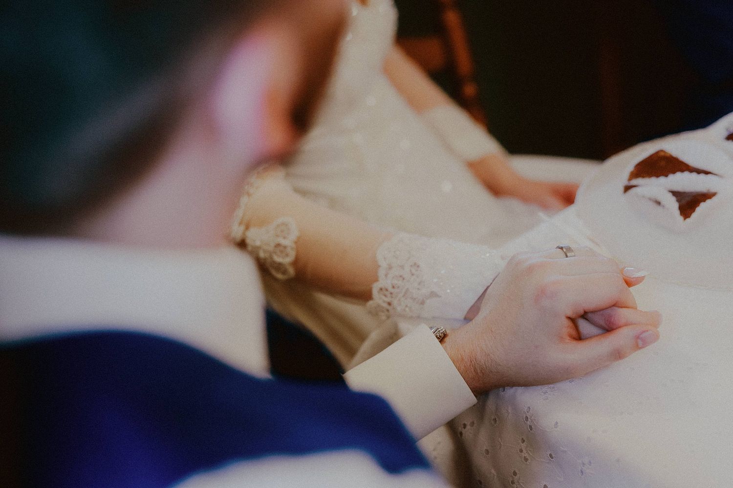 Close up of hands exchanging wedding rings during an intimate ceremony.