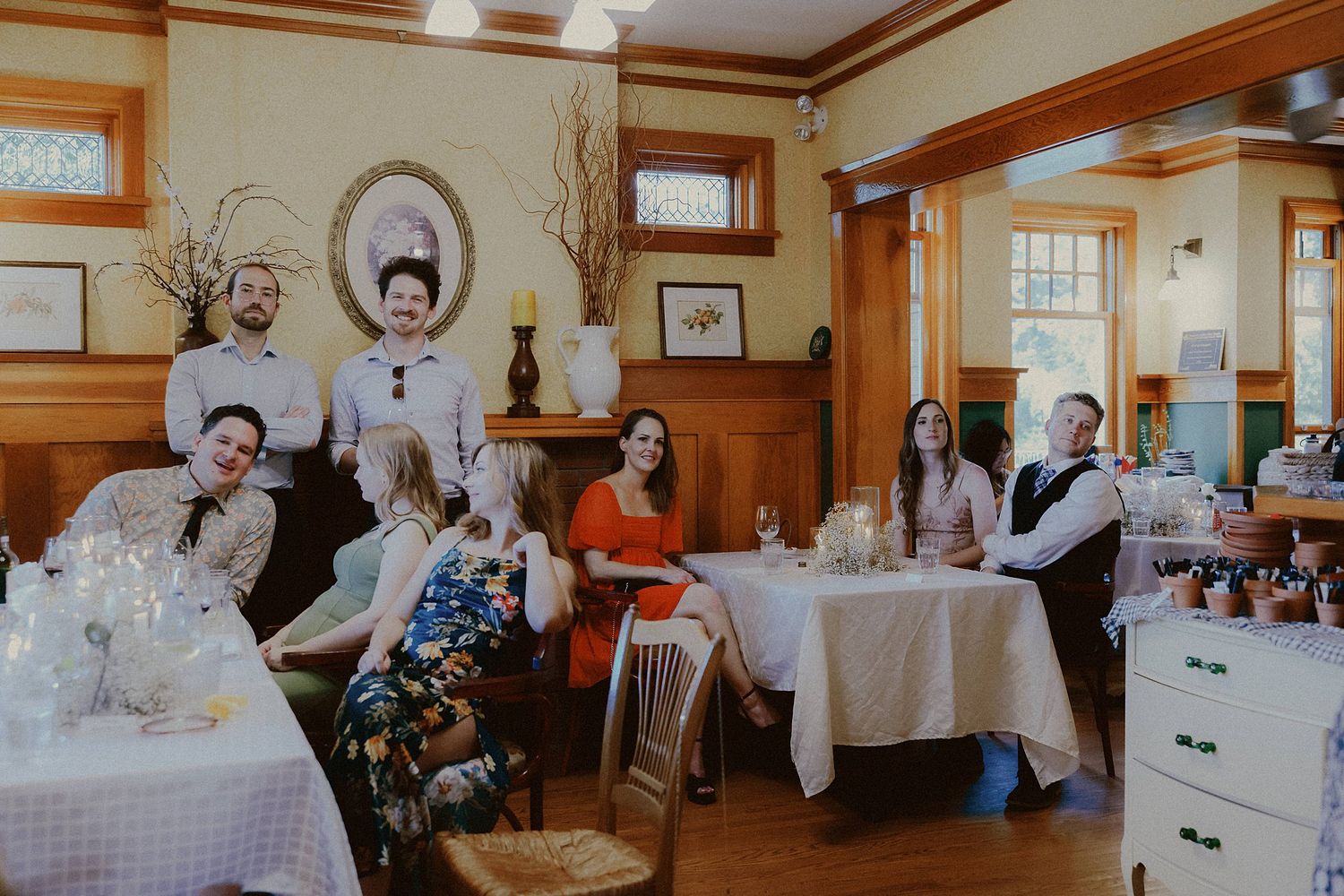 Wedding reception in a rustic wood-paneled room with decorated tables.