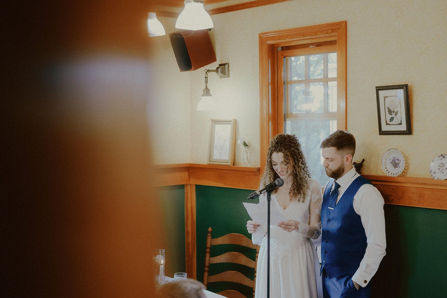 Indoor wedding ceremony with warm lighting and wooden architectural details.