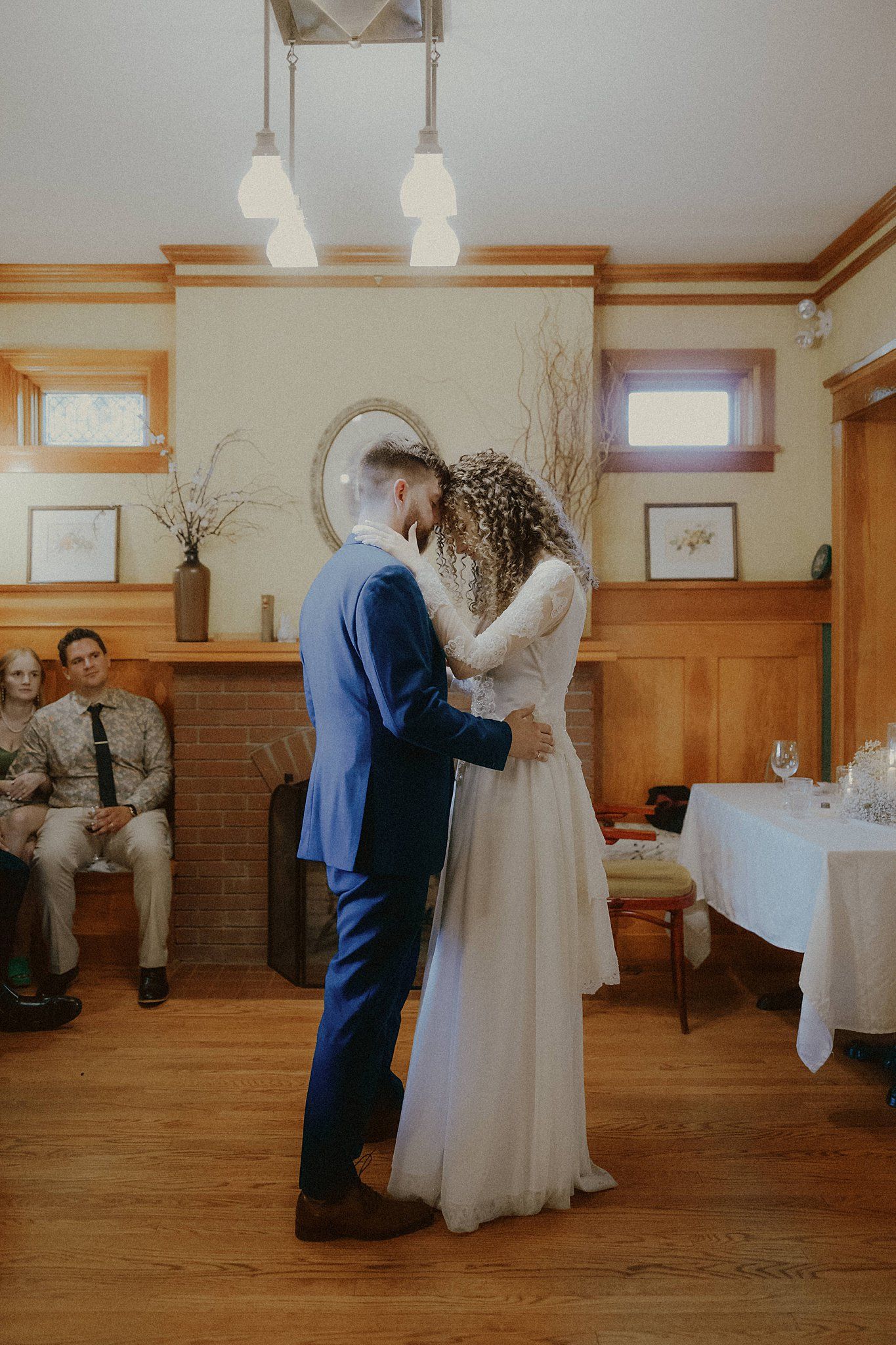 Indoor wedding ceremony moments in a wooden-paneled room with natural lighting.