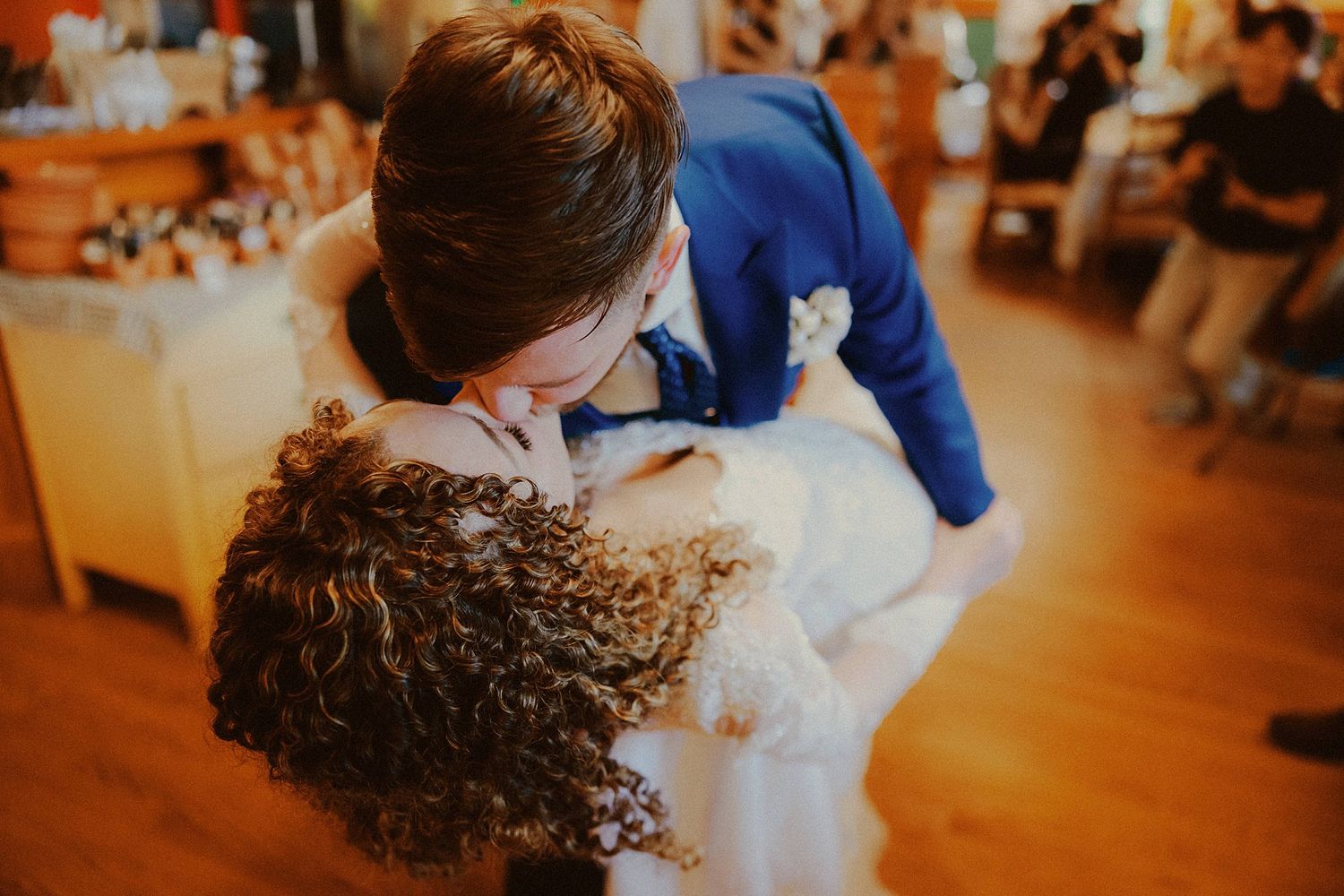 Guests dancing and celebrating on a wooden floor during a wedding reception.