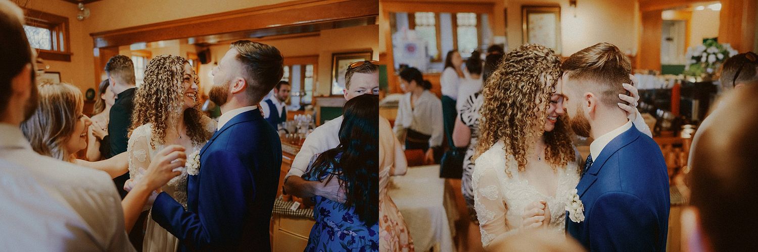 Wedding guests mingling and celebrating inside a warm wooden reception venue.
