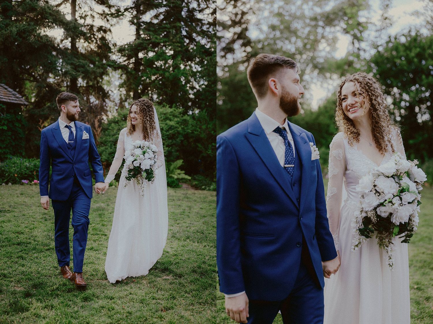 A romantic wedding couple poses in a garden setting wearing navy blue suit and white lace gown with floral bouquet.