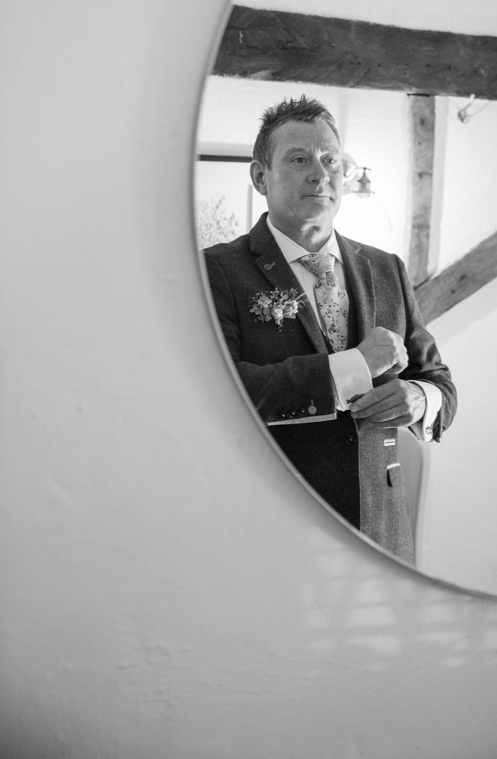 Black and white sequence of mirror reflections showing a man adjusting his formal attire.
