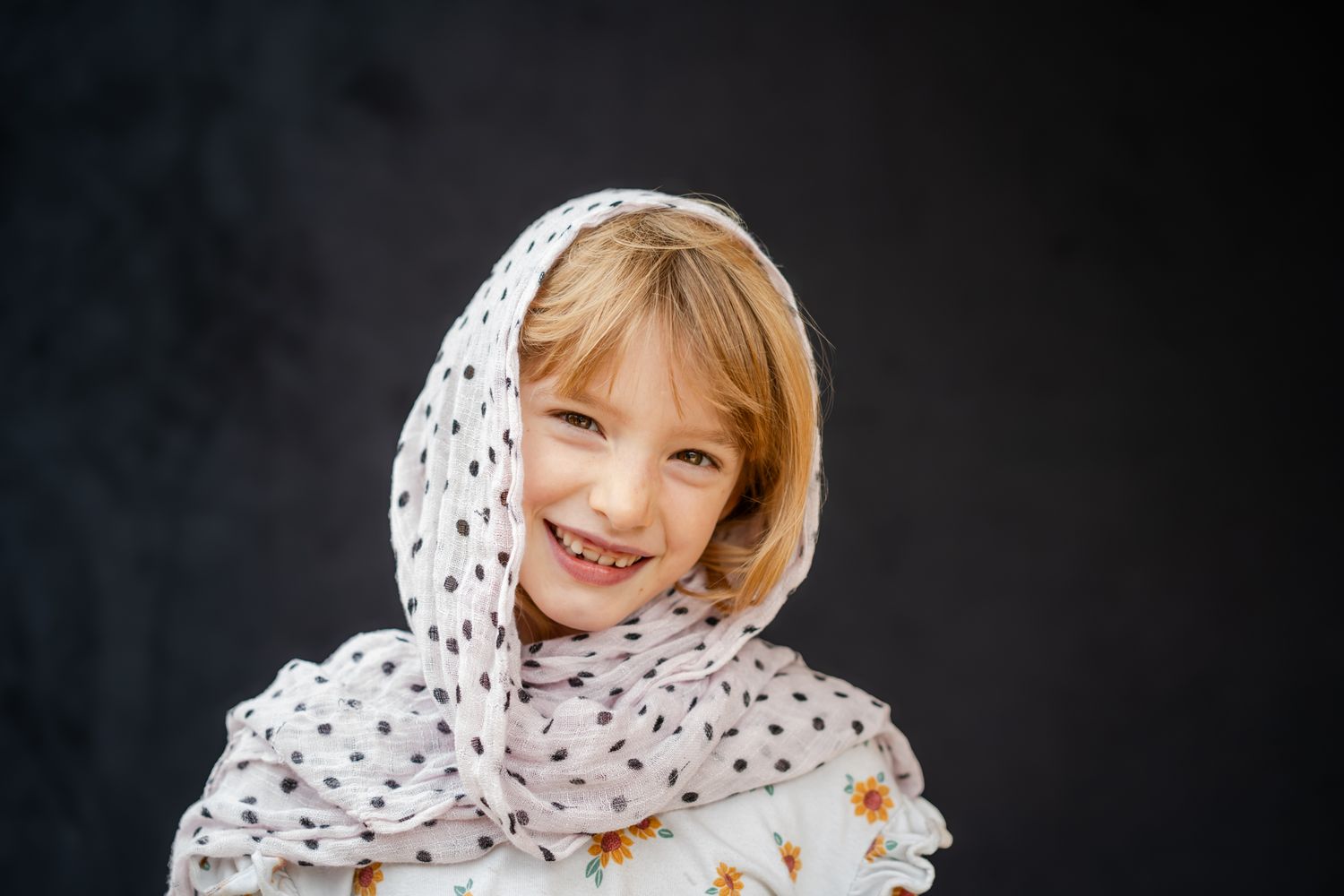 school portrait of a smiling girl with black background
