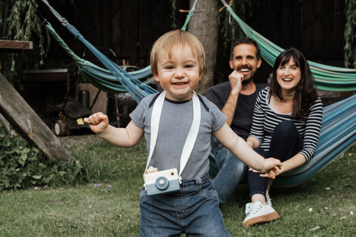 Family enjoying leisure time with hammocks in a backyard garden setting.