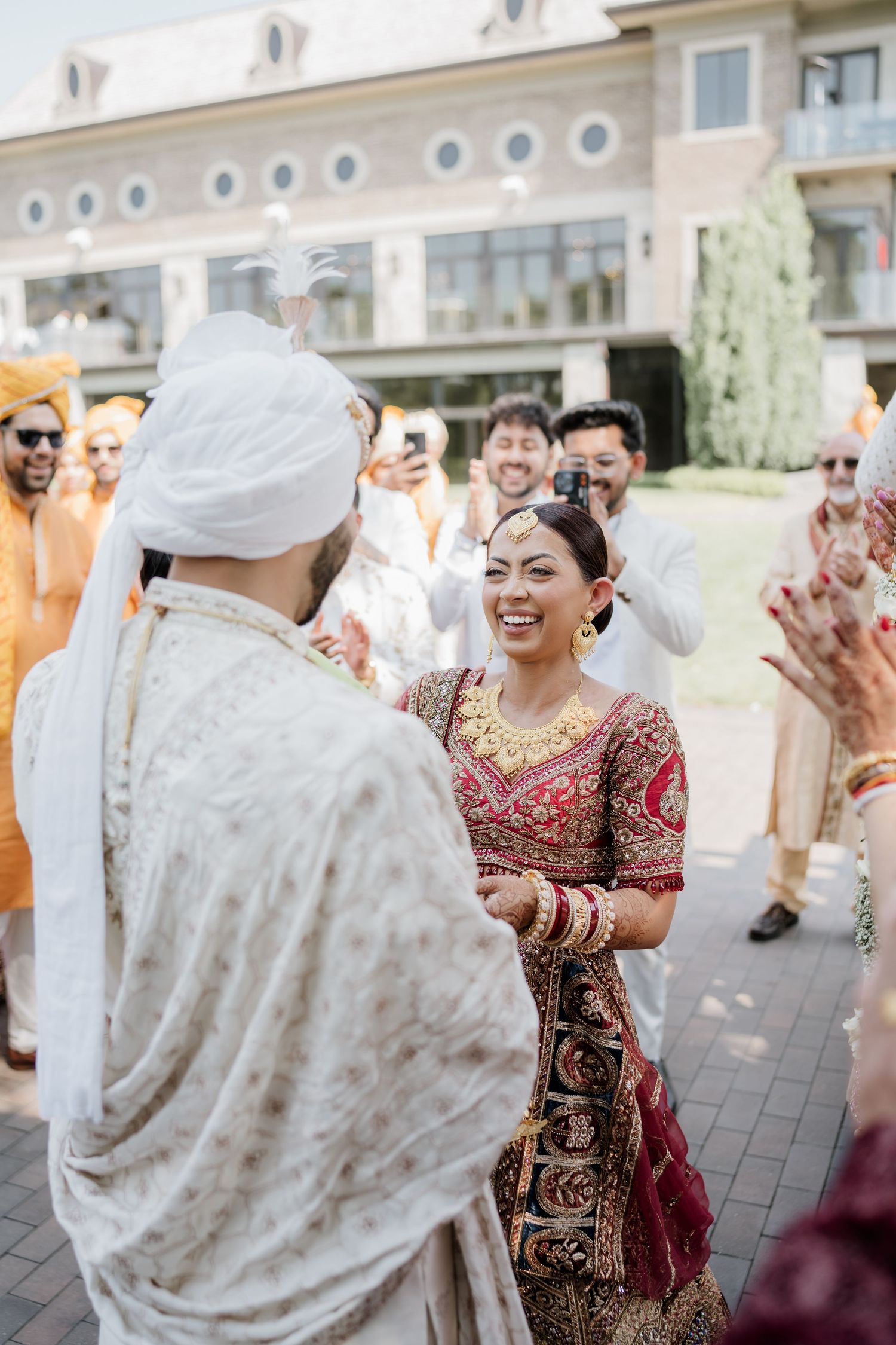 A joyous celebration at an outdoor wedding venue with guests in traditional attire dancing and enjoying the festivities.