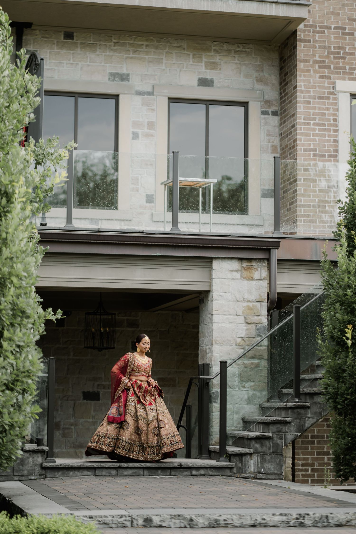 A stone and brick building exterior with modern architectural elements and landscaping creates an elegant backdrop.
