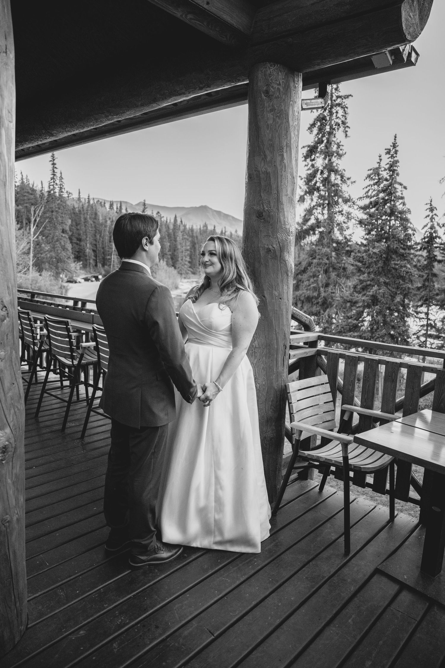 Black and white photo sequence of a couple dancing on a rustic wooden deck with mountain views in the background.