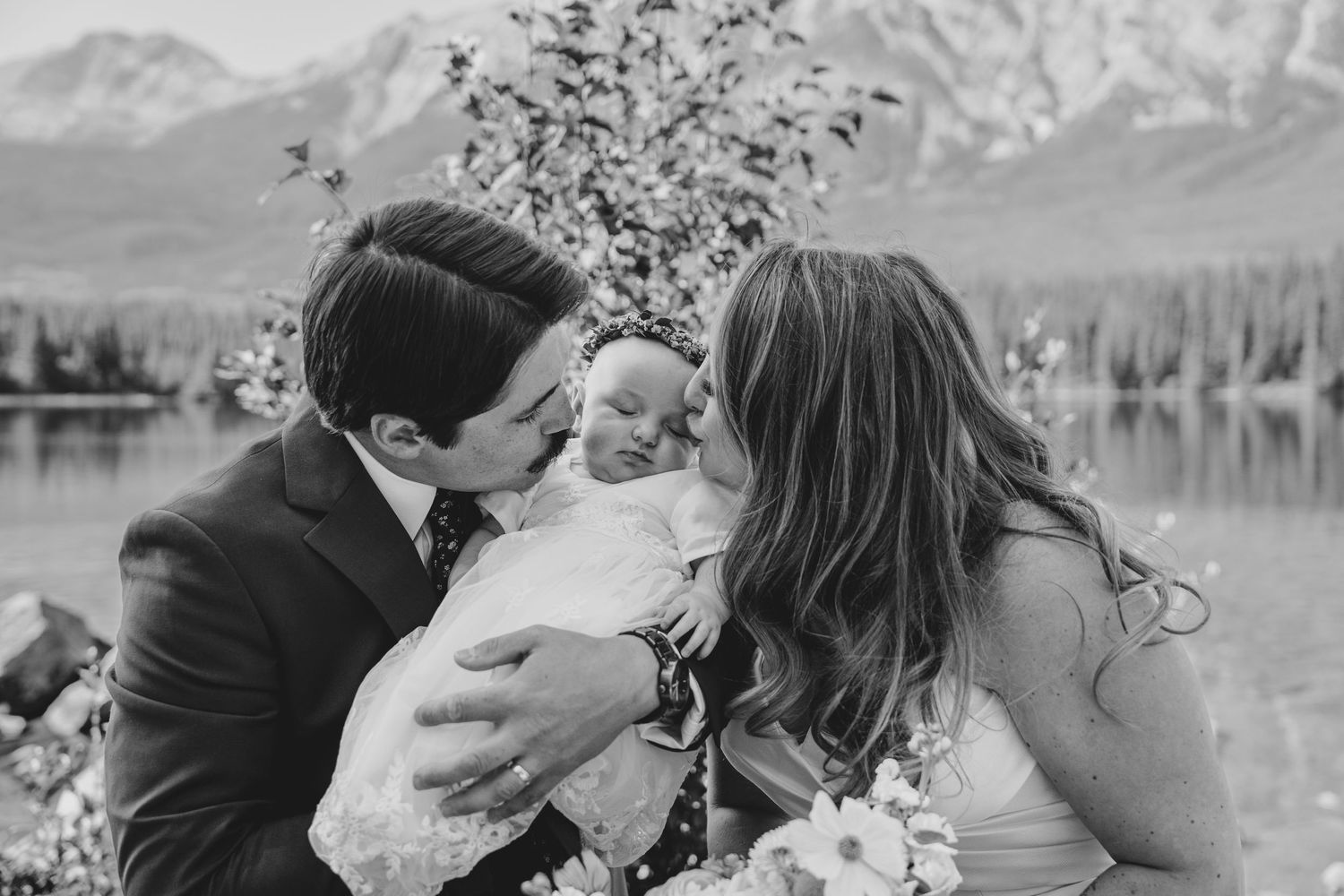 A romantic black and white photo collage showing tender moments between a couple near a scenic mountain lake.