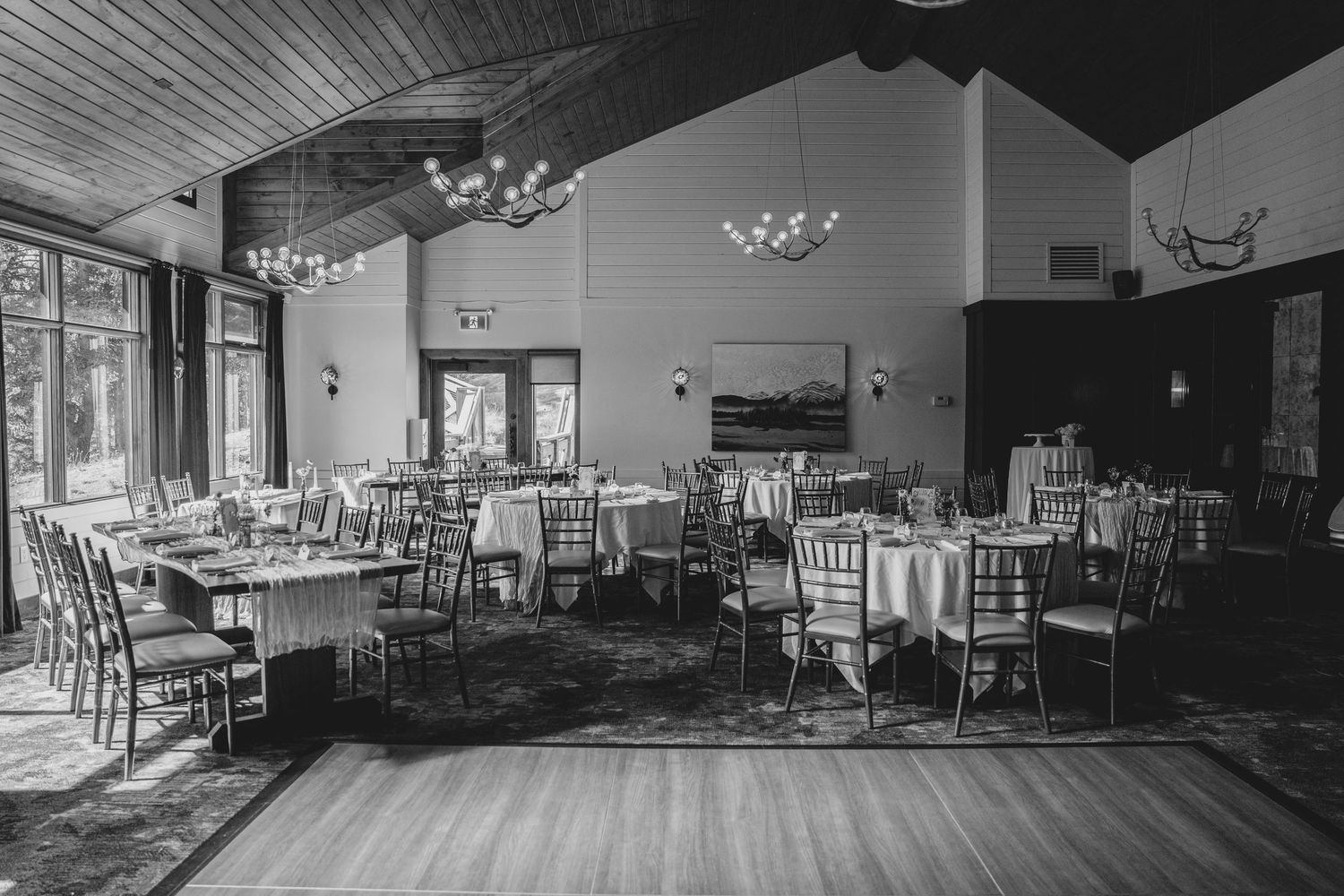 Empty banquet hall with multiple round tables and chairs arranged in a spacious setting.