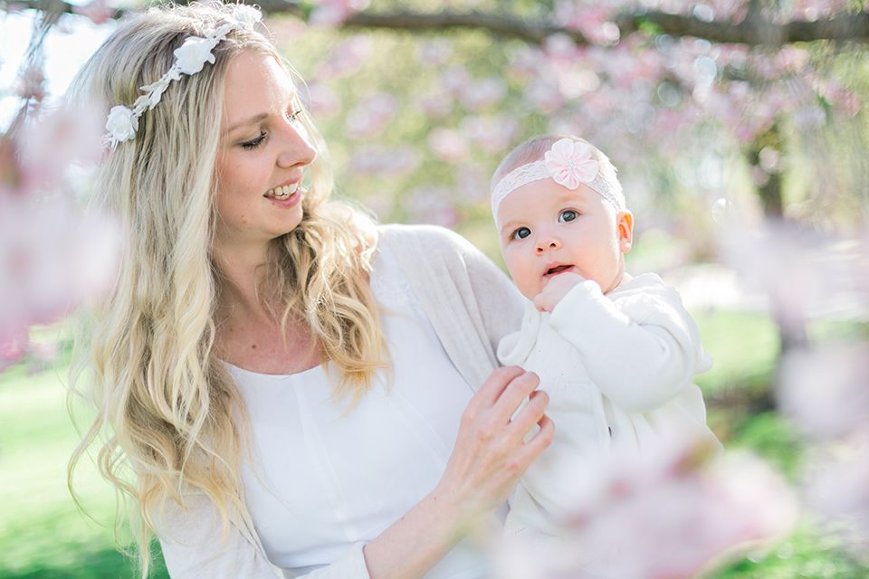 Barn- och familjefotografering i Stadsträdgården, Karlstad. Angelina håller i bebis-Melissa med glosor runt dem.