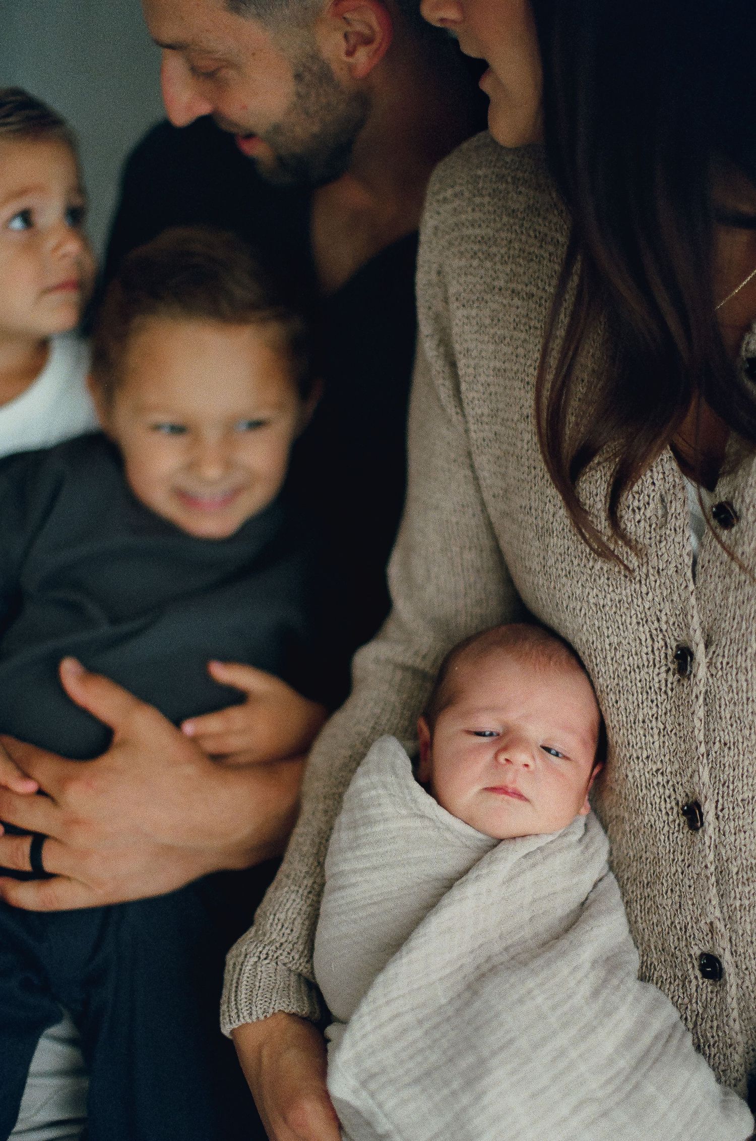 Candid series showing tender family moments with a baby in warm indoor lighting.