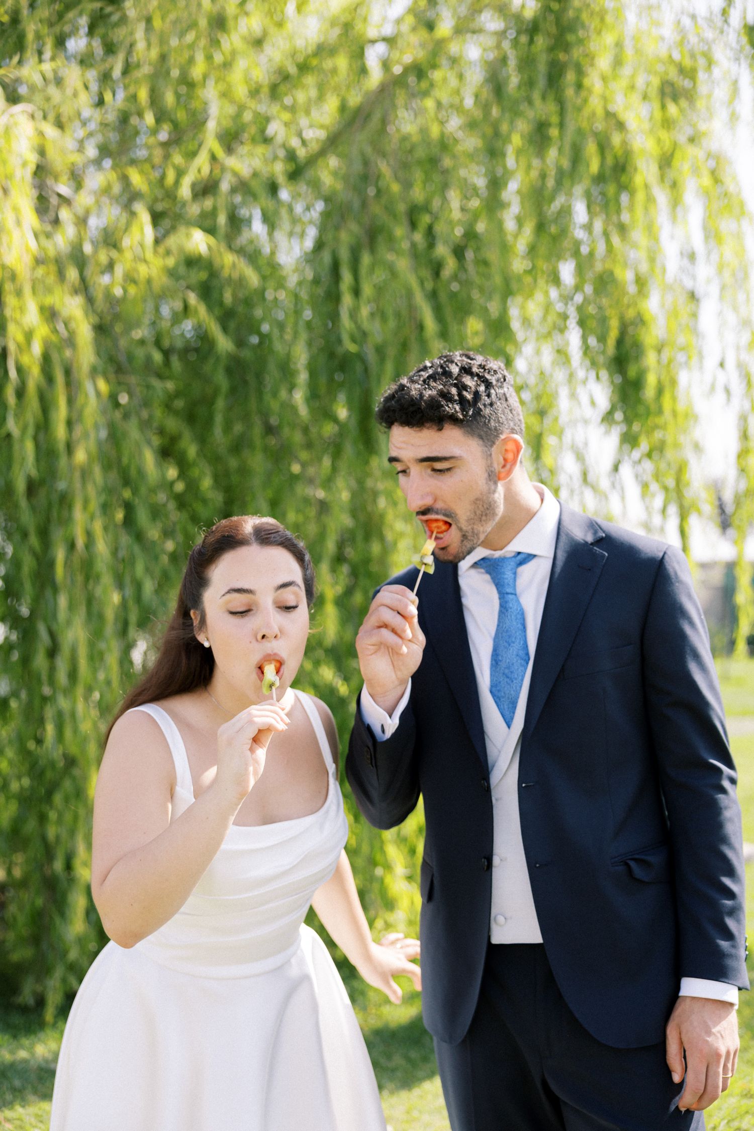 fun photo of wedding couple eating canapes at their wedding, captured by Portugal wedding photographer