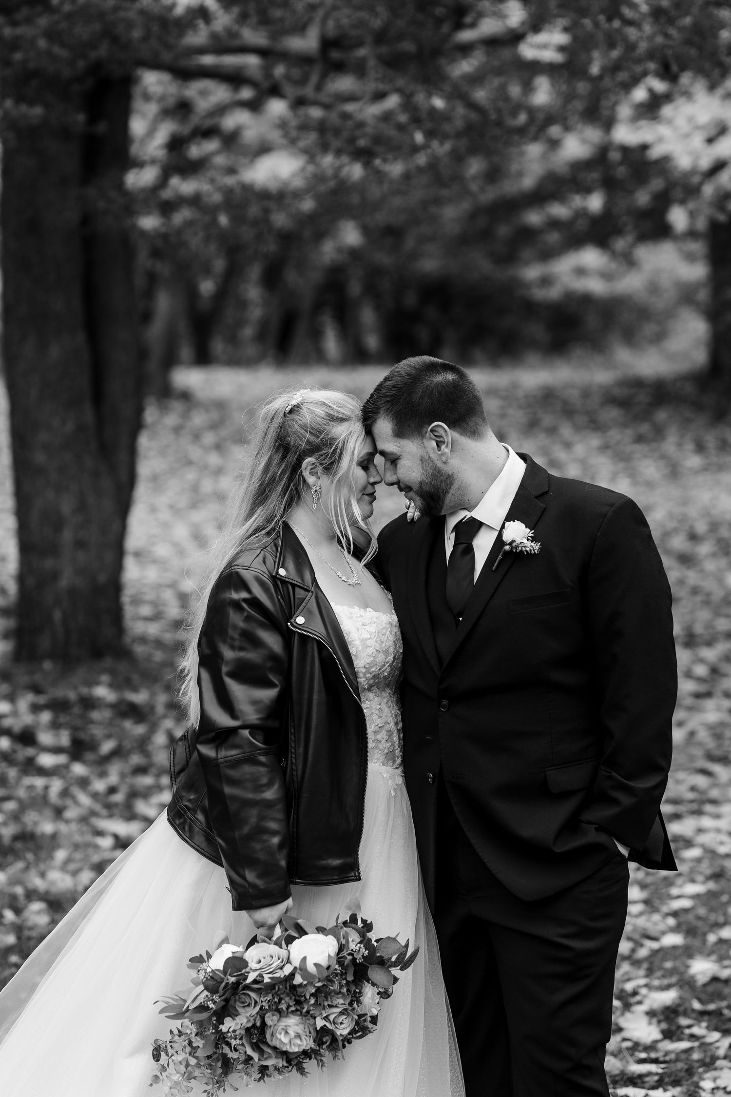 A romantic series of black and white wedding photos showing tender moments between a couple in an autumn setting.