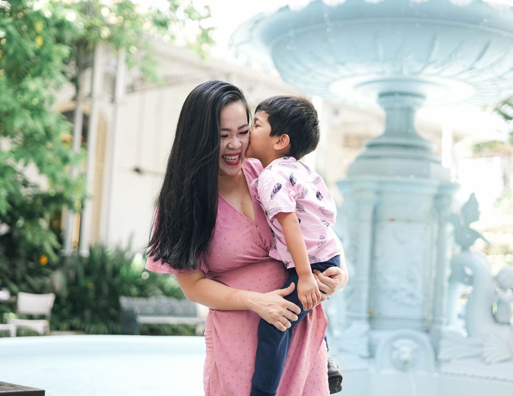 A heartwarming outdoor photo session showing tender moments between parent and child in a garden setting.