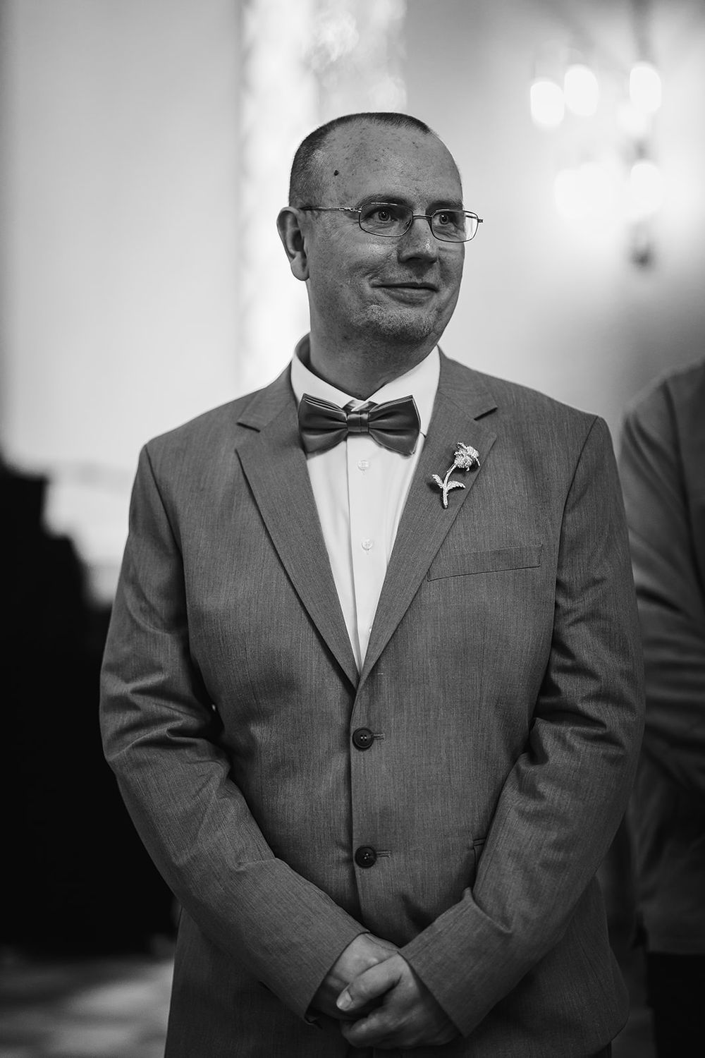A series of five black and white photos showing a person wearing glasses and a formal suit.