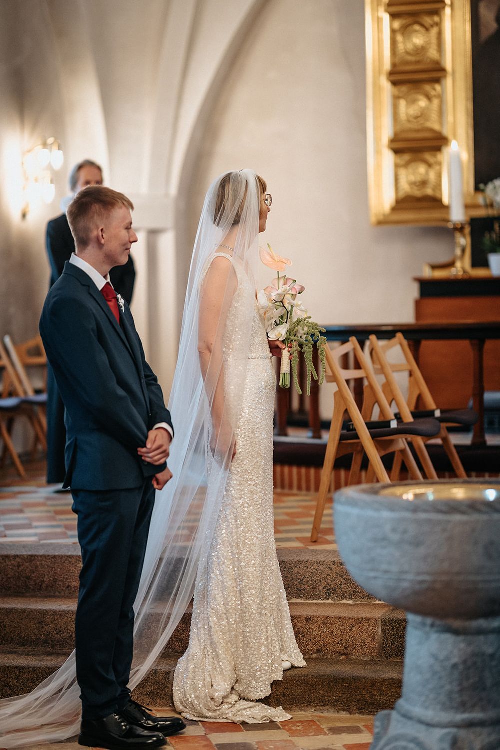 A series of four photos showing a tender moment between a bride in a lace dress and a young boy in a suit at church.