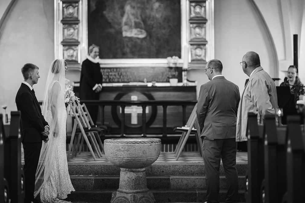 A black and white panoramic view of a church interior during a wedding ceremony.