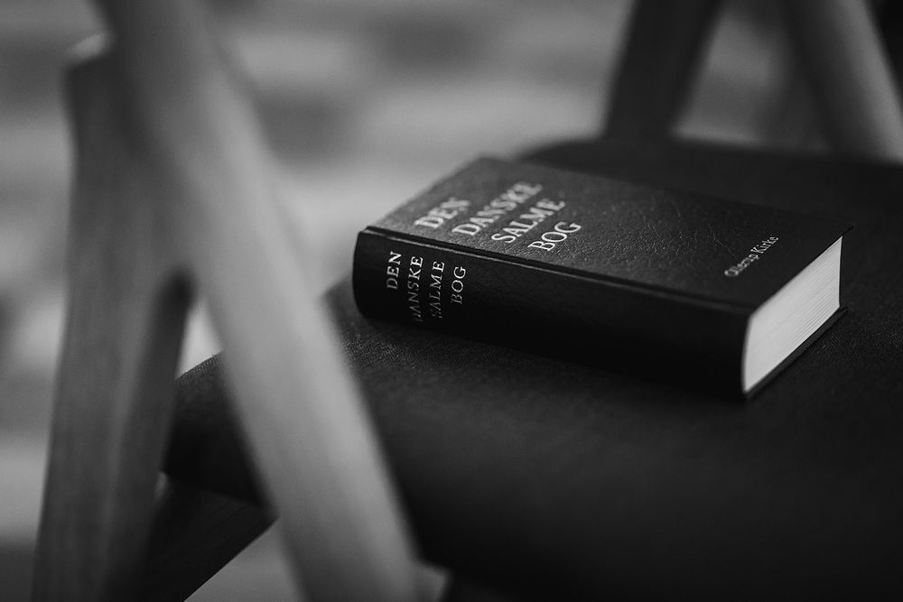 Black and white detail of church interior with organ pipes and arched architecture.