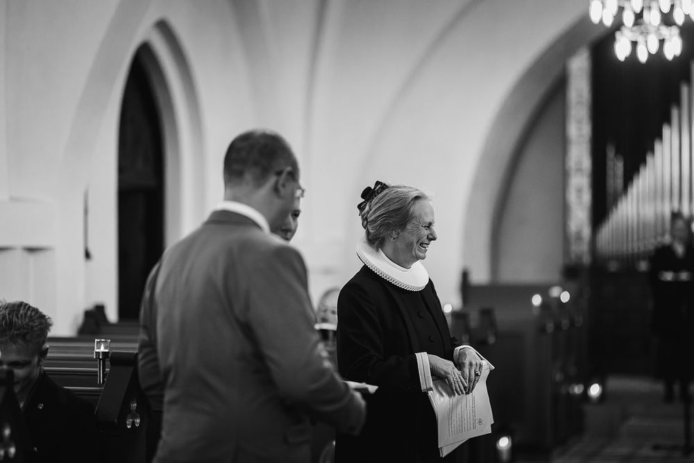 Church sanctuary with elegant chandeliers and arched ceiling in dramatic lighting.
