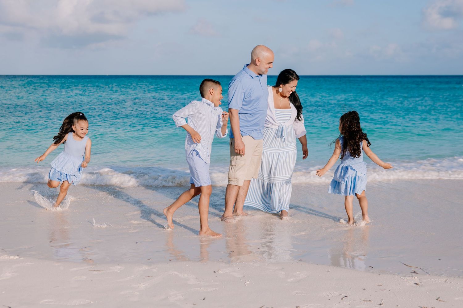 Group enjoying a playful moment running together on a pristine Caribbean beach.