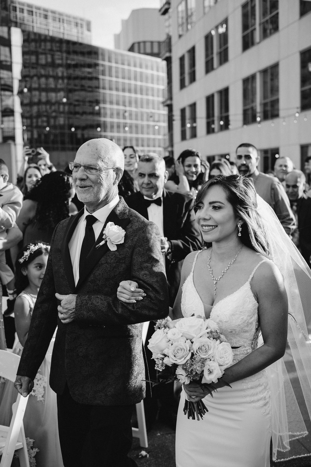 Wedding party celebrating outdoors in front of modern city buildings. Orlando downtown rooftop wedding. Florida photographer, videographer.