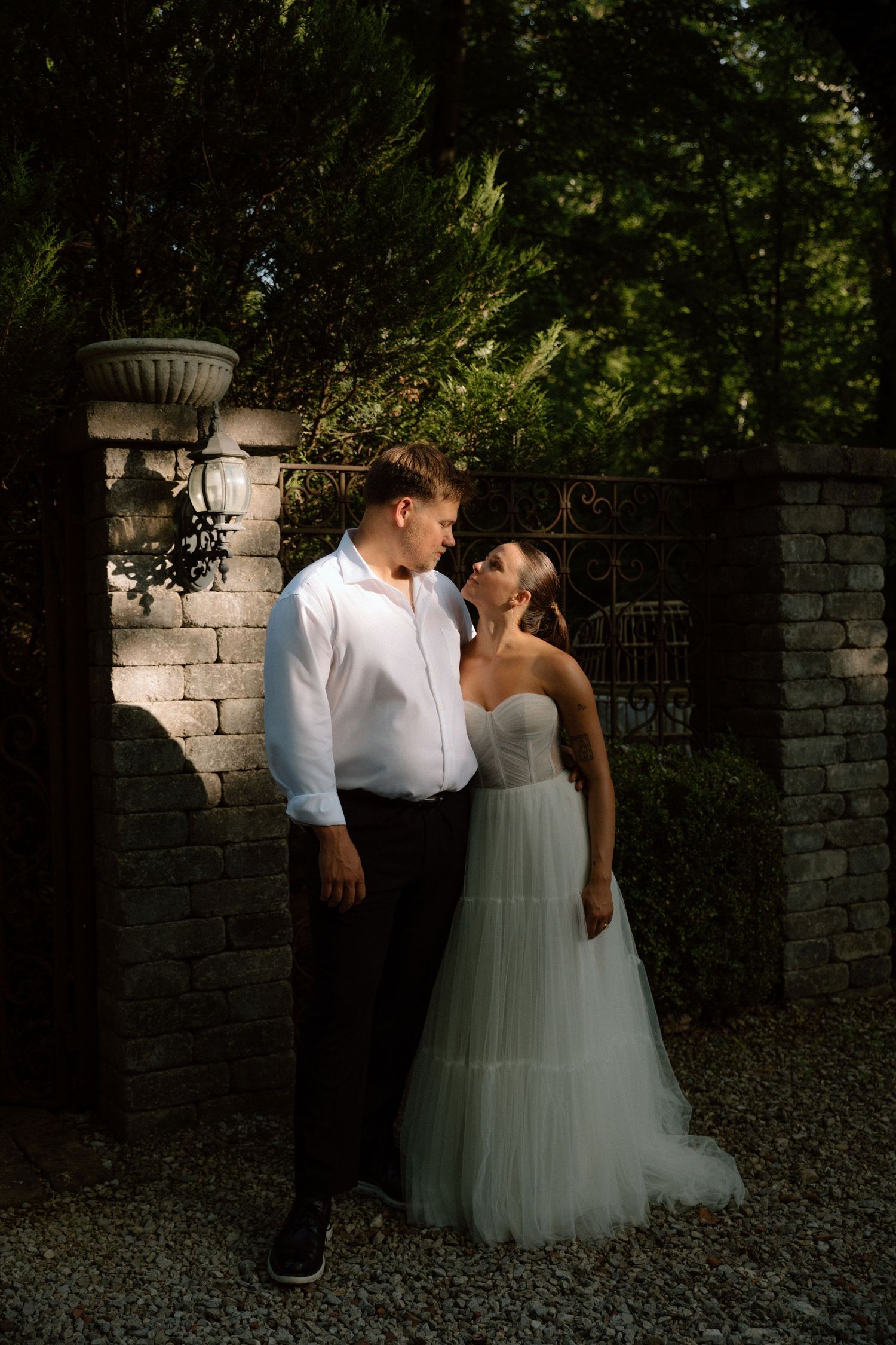 A romantic wedding photo sequence showing a couple in formal attire posing against a stone wall in a garden setting.