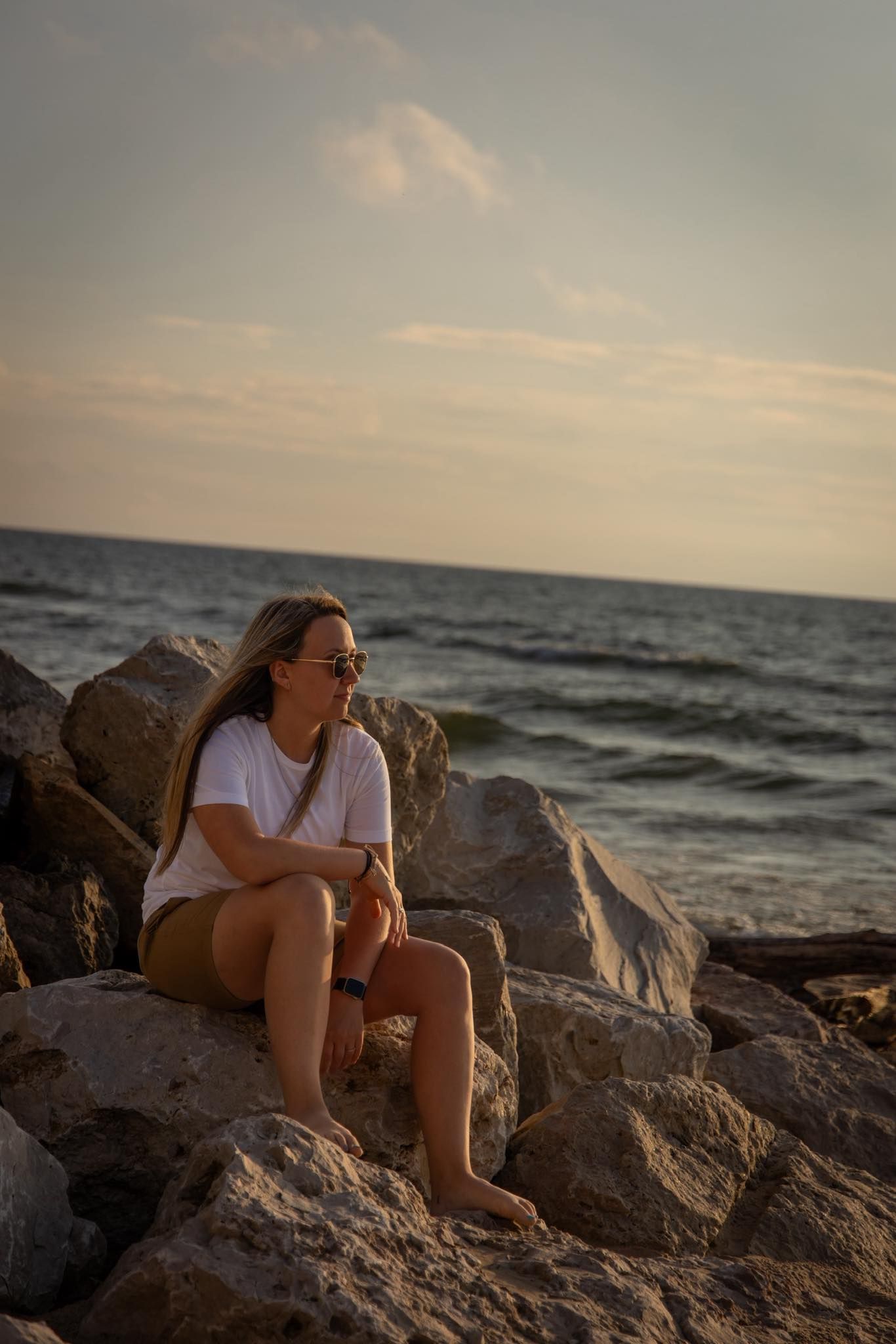A woman sitting on a rock on a beach