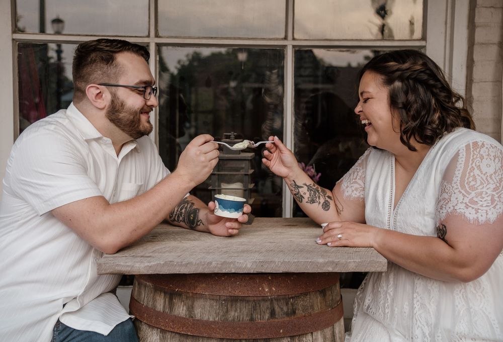 Wedding couple shares drinks and laughter at rustic wooden bar setting in Canal Fulton, Ohio.
