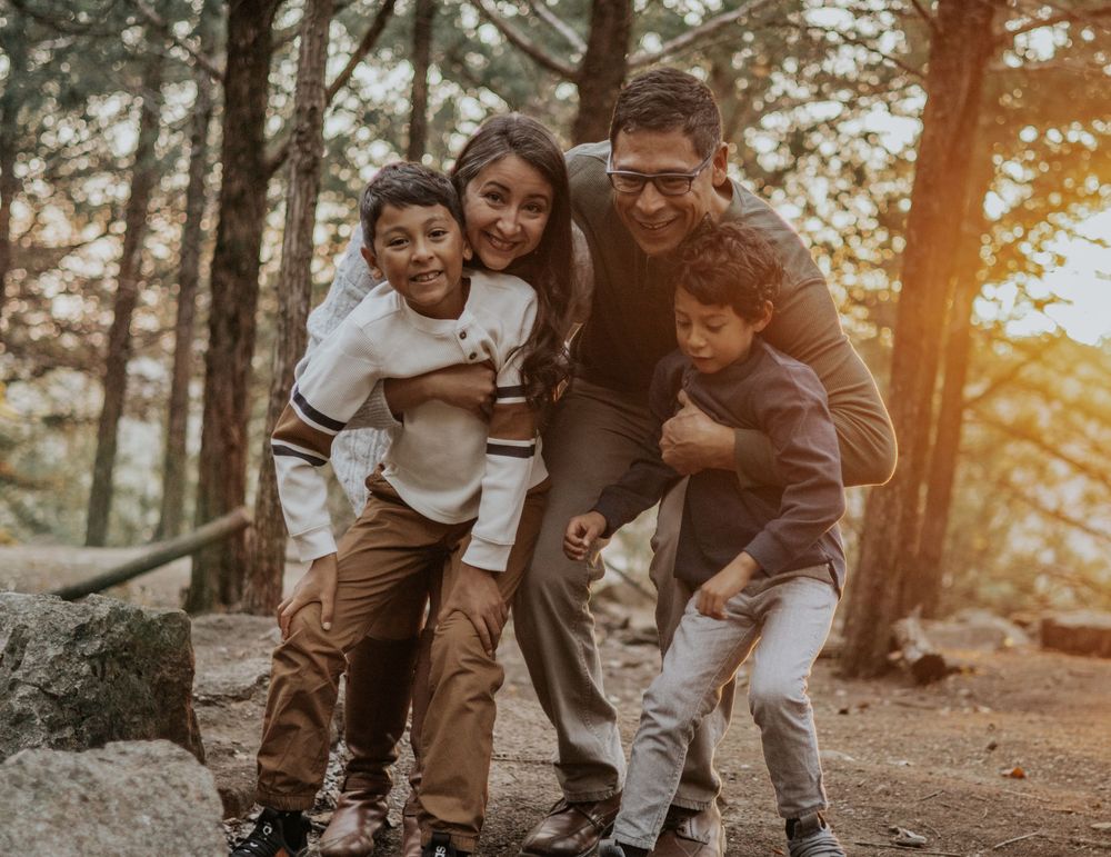 Family laughing together during a warm, candid outdoor lifestyle session.