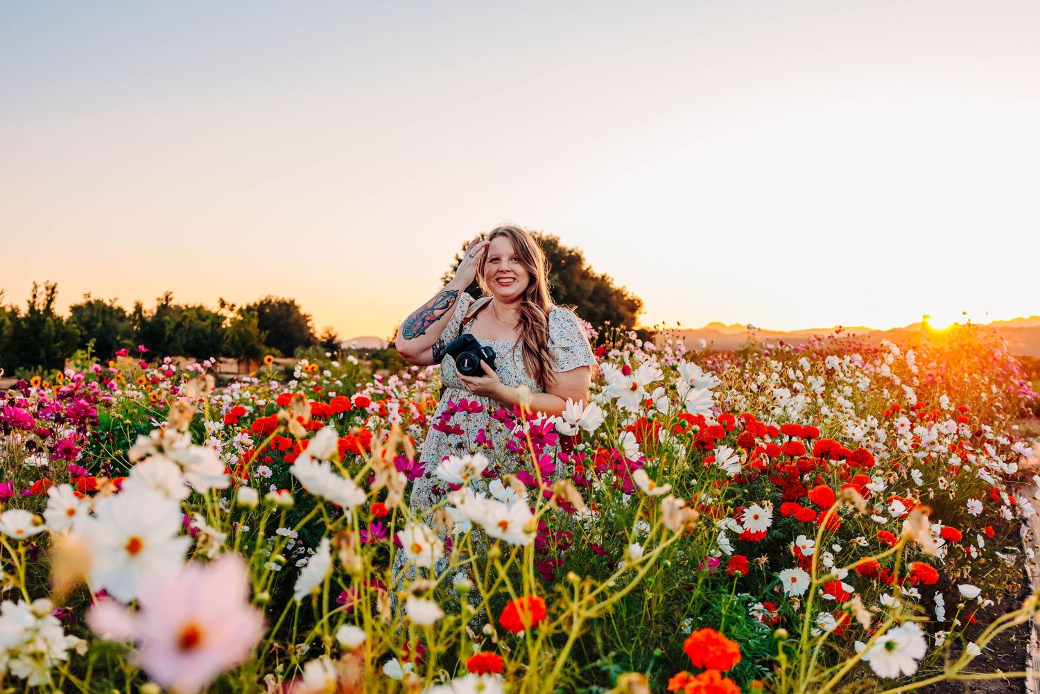 A person dances joyfully in a vibrant field of red poppies and white wildflowers during golden hour sunset.