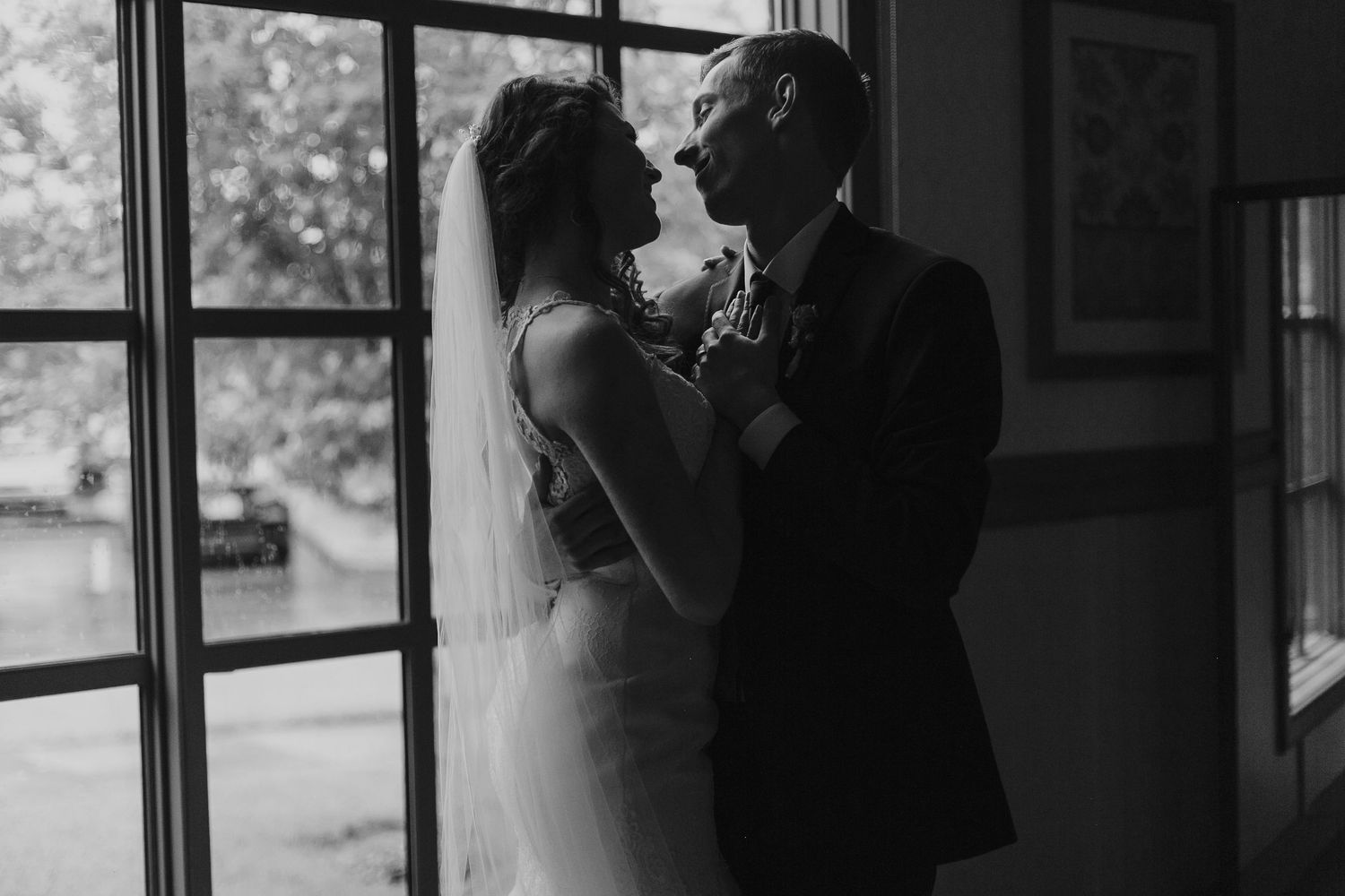 Bride and groom sharing a romantic kiss under a flowing white wedding veil.