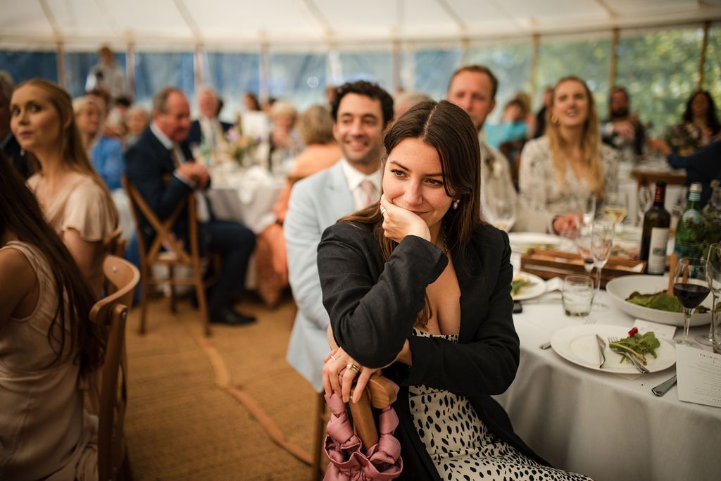 Emotional wedding guest in black blazer smiling at reception in elegant marquee tent in Backyard wedding guests Nova Scotia