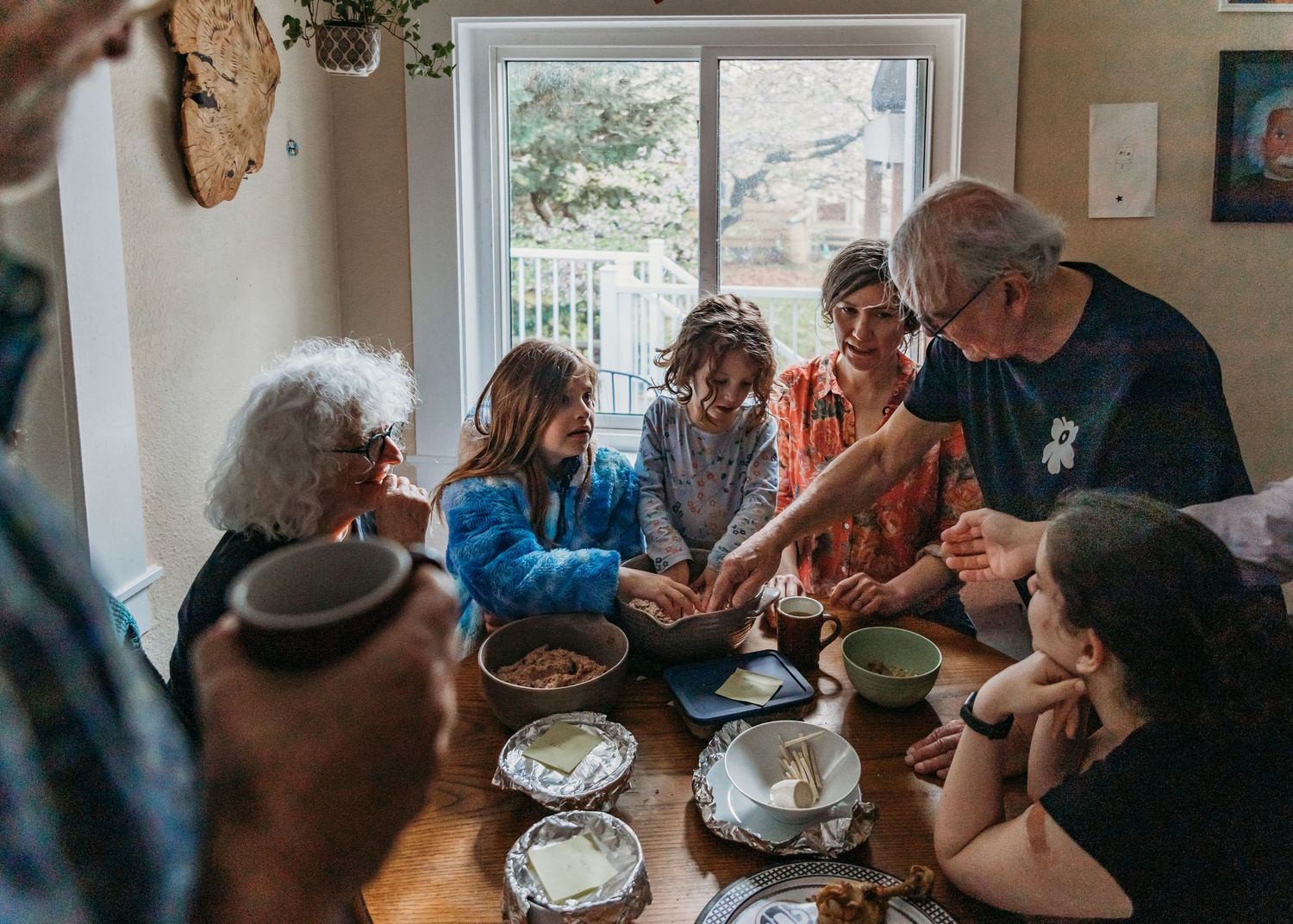 Family gathered around a dining table sharing a meal during a Jewish Shabbat or holiday celebration at home.