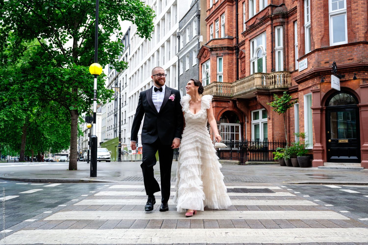 A series of black and white wedding photos showing a bride in a ballgown and guests at an elegant indoor reception.