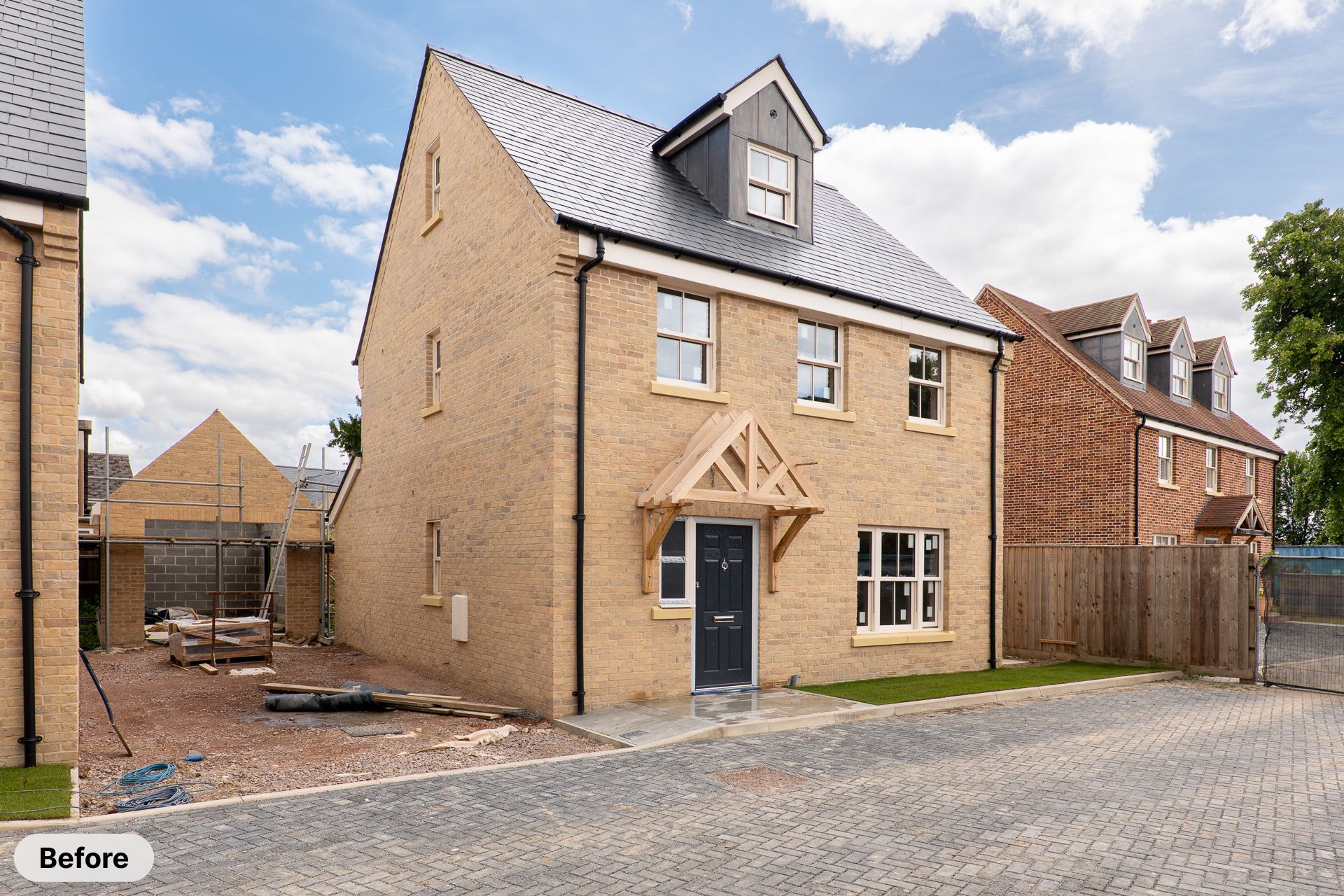 Newly built detached family home with sandstone facade, oak porch, dark front door, and block paved driveway.